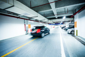 Schwarzes, fahrendes Auto in Tiefgarage