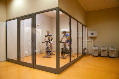 Exercisers on bike in glass room