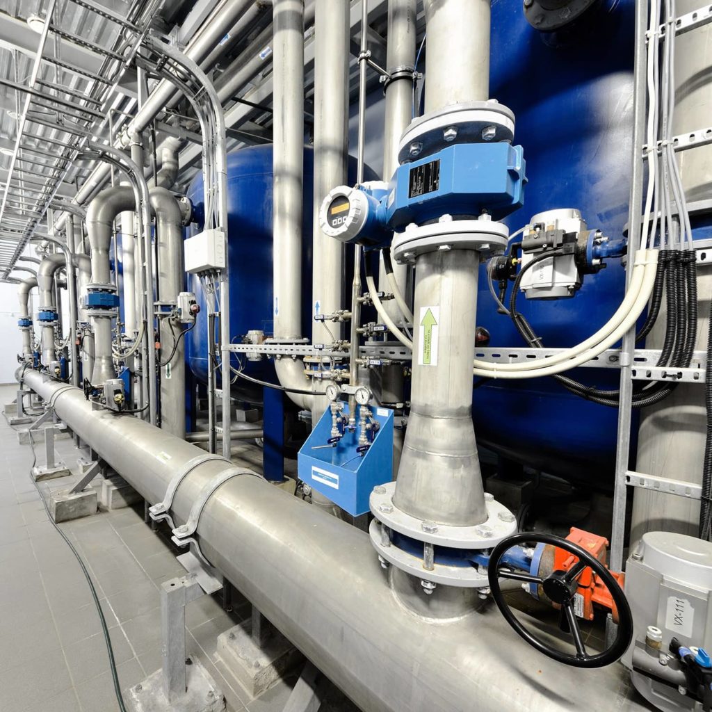 Boiler room with grey pipes and blue boilers