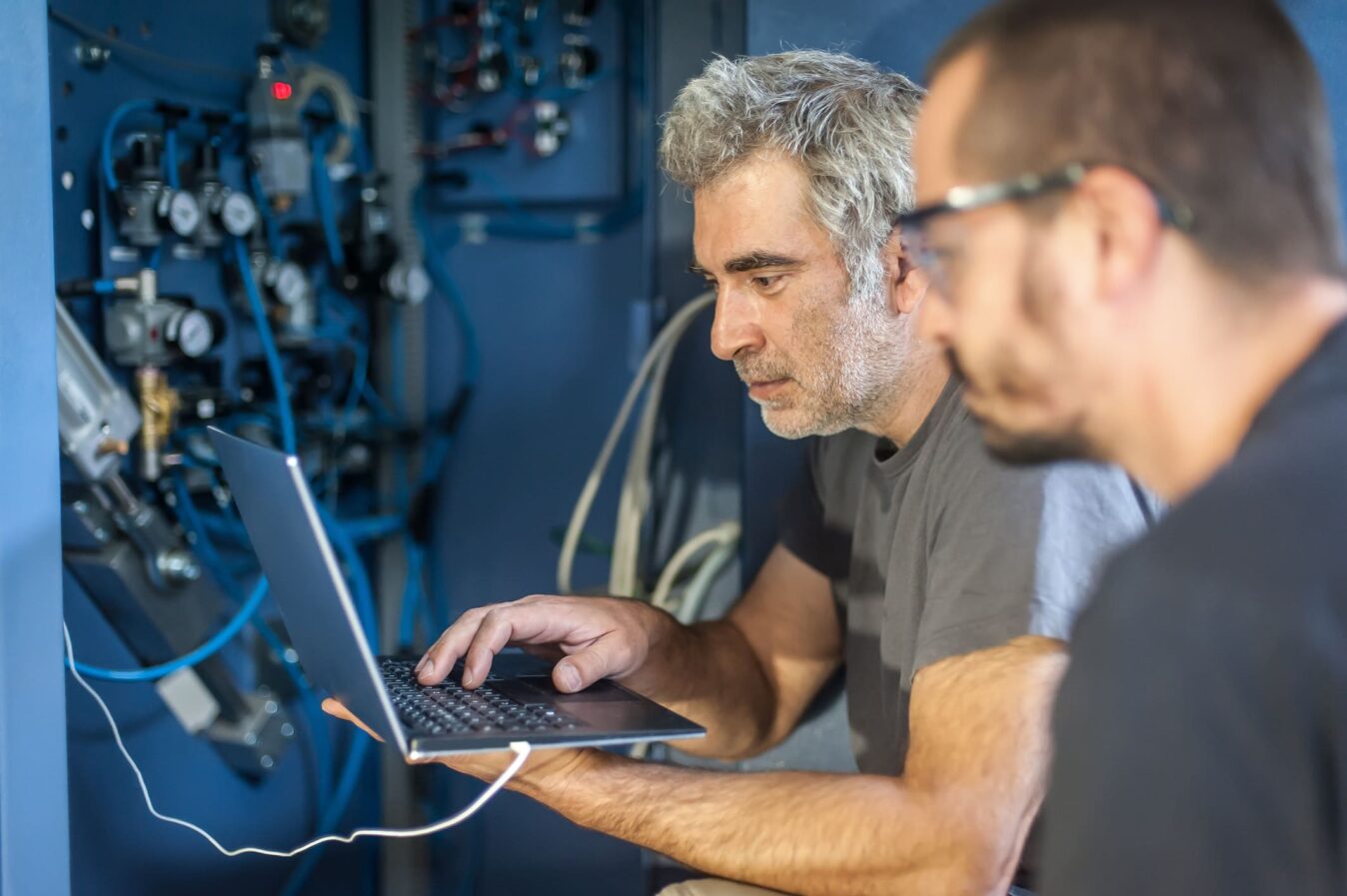 Two people carrying out calibration and maintenance on a gas warning system.